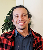 male with brown hair wearing black red shirt